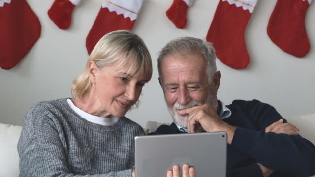 Senior-ältere-kaukasische-alte-Mann-und-Frau-mit-Tablet-und-Online-Internet-spielen-zusammen