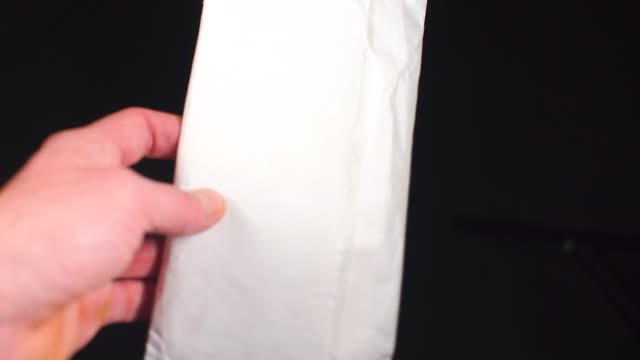 A-man-shifts-a-white-envelope-from-hand-to-hand.