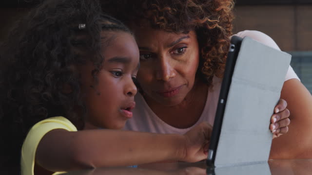 Nahaufnahme-von-afroamerikanischen-Großmutter-und-Enkelin-zu-Hause-mit-digitalen-Tablet-zusammen