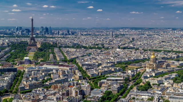 Vista-aérea-de-la-torre-de-Montparnasse-con-la-Torre-Eiffel-y-el-barrio-de-La-Defense-en-timelapse-de-fondo-en-París,-Francia