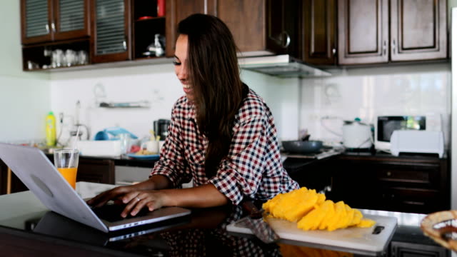 Girl-Use-Laptop-Computer-In-Kitchen-Chatting-Online-Young-Woman-Studio-Modern-House-Interior