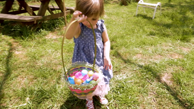 Muchacha-adorable-2-3-años-en-vestido-de-primavera-sosteniendo-una-canasta-de-Pascua