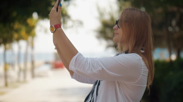Mujer-haciendo-selfie-al-caminar-con-el-bebé-al-aire-libre