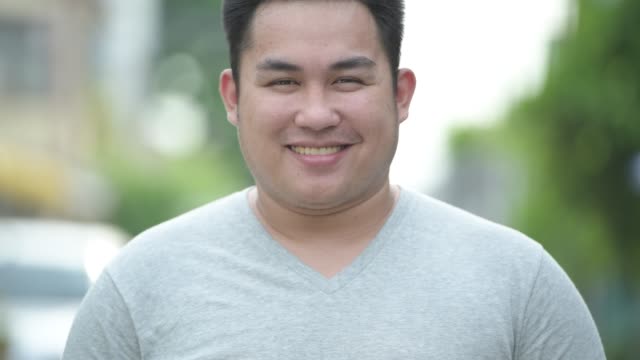 Young-handsome-overweight-Asian-man-in-the-streets-outdoors