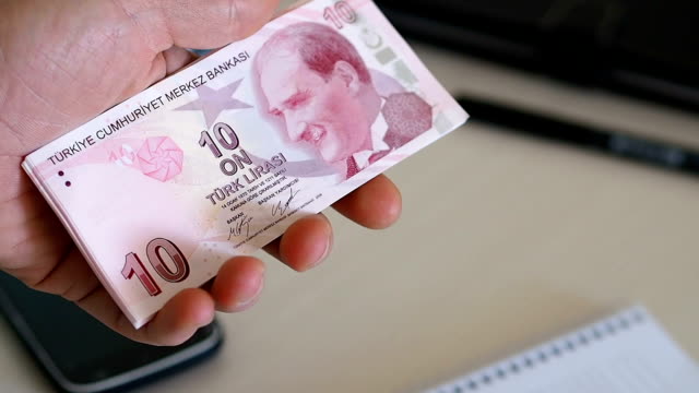 die-Person-zählen-türkische-Banknote.-zehn-türkische-lira