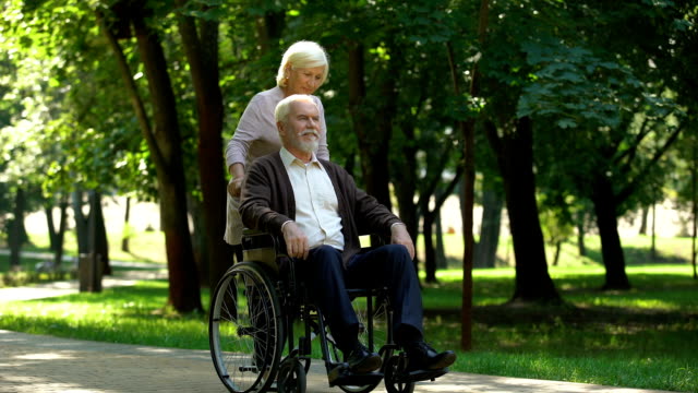 Pareja-adulta-caminando-en-el-parque,-esposa-besando-a-su-marido-discapacitado,-rehabilitación