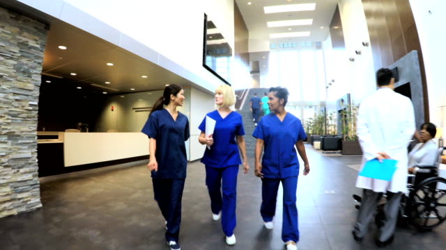 Multi-ethnic-nurses-wearing-scrubs-in-hospital-entrance