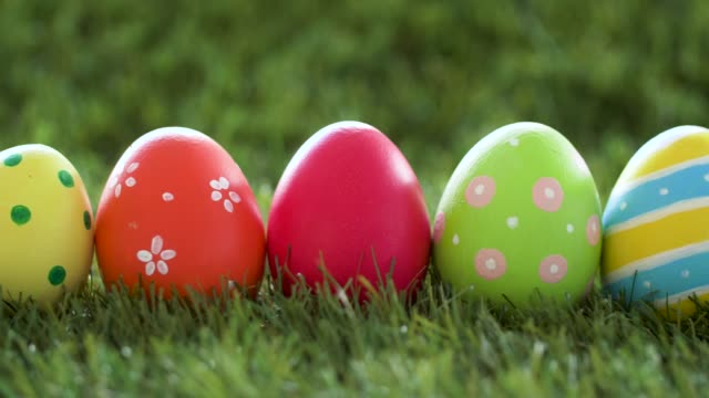 row-of-colored-easter-eggs-on-artificial-grass