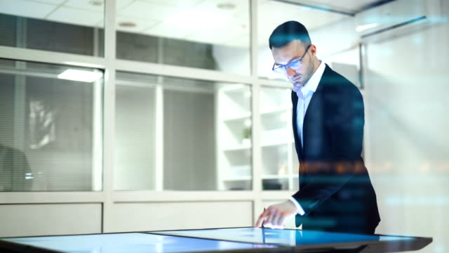 Der-Geschäftsmann-arbeitet-mit-einer-großen-Leinwand-auf-dem-Hologramm-Hintergrund