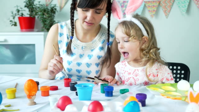 Madre-ayudando-hija-a-pintar-conejito-de-Pascua