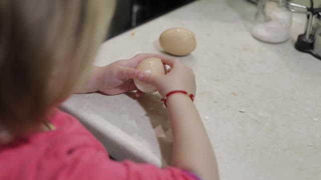 Nahaufnahme-eines-kleinen-Mädchens-reinigt-die-Schale-mit-einem-gekochten-Hühnerei