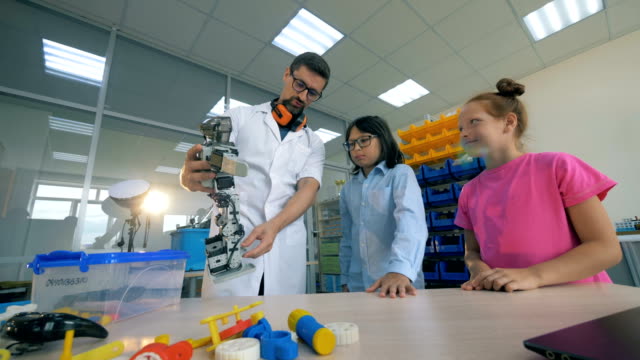 Robotertechnologien-in-der-Grundschule.-Schullehrer-studieren-Robotik-Technik-mit-intelligenten-Schülern