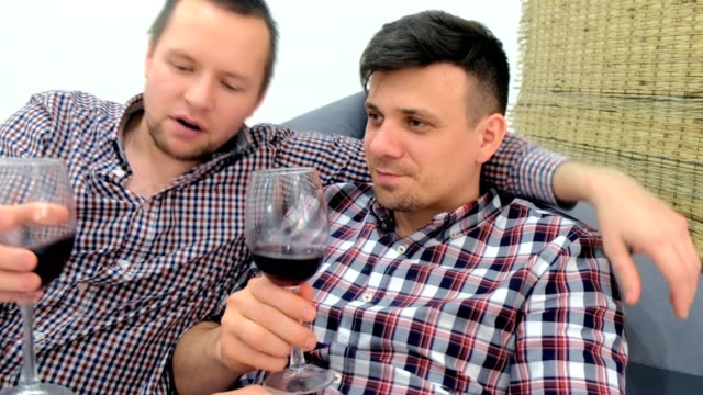 Männer-Schwule-entspannen-und-trinken-einen-Rotwein-umarmen.