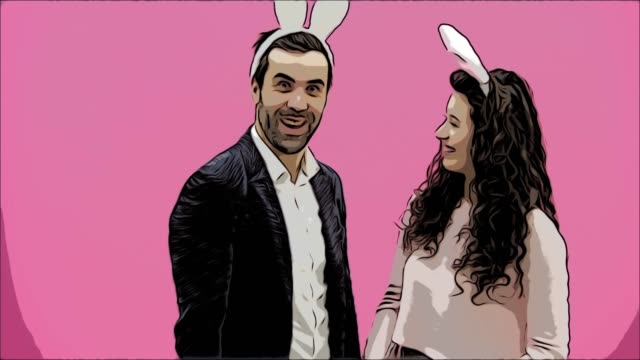 Young-lovers-couple-on-the-pink-background.-With-hackneyed-ears-on-the-head.-During-this,-the-girl-wears-rabbit-ears-to-her-husband.-After-that,-they-begin-to-make-a-photo-of-sephi-on-the-phone.-Very-smiling.-Animation.