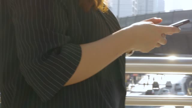 Nahe-Hand-junge-asiatische-Frau-zu-Fuß-Texting-mit-Freund-auf-dem-Smartphone-auf-städtischen-Stadthintergrund,-Suche-nach-sozialen-Medien