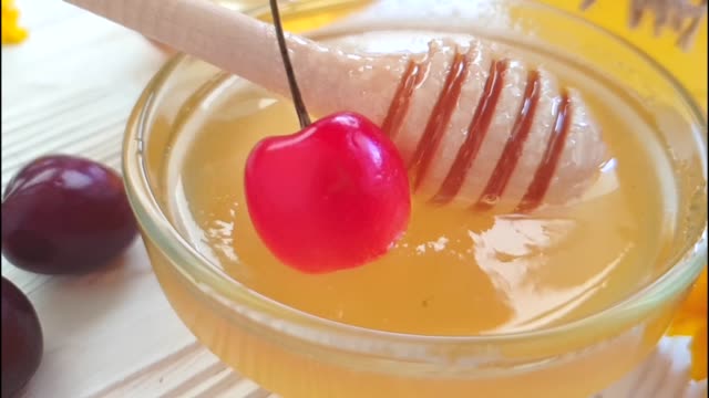 fresh-honey-cherry-on-white-wooden-slow-motion