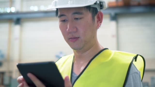 Junge-asiatische-männliche-Fabrikarbeiter-mit-einem-digitalen-Tablet