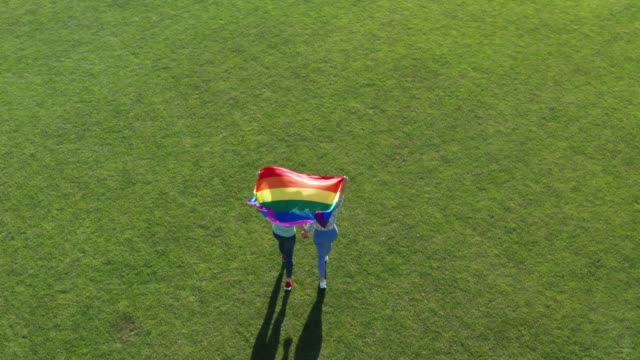 Aerial-shot-of-lgbt-couple-walking-with-pride-flag