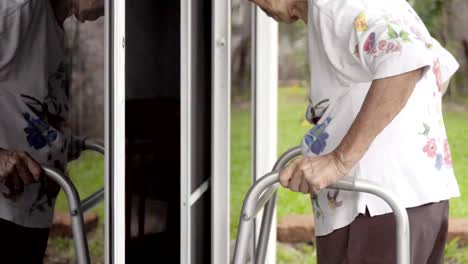 Elderly-woman-with-key-opening-front-door.