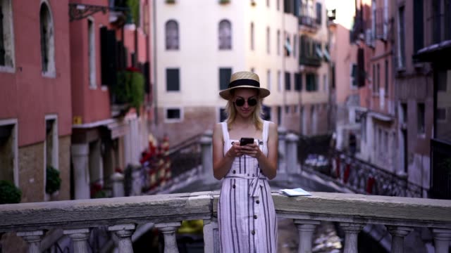 Zeitlupeneffekt-von-jungen-attraktiven-Touristinnen-in-lässigem-Look-gekleidet-Lesen-erhalten-E-Mail-über-Bestätigung-Informationen-nach-der-Buchung-Hotel-in-Venedig