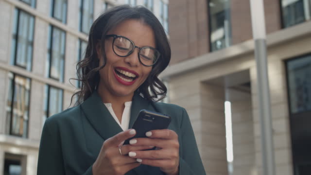 Happy-Businesswoman-Using-Smartphone-Outdoors
