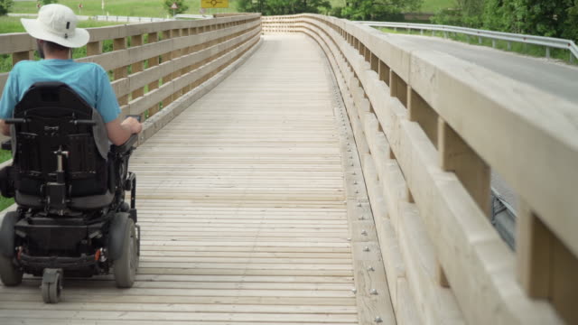 4k-Auflösung-Video-von-einem-Mann-auf-elektrischen-Rollstuhl-fahren-auf-Fußweg