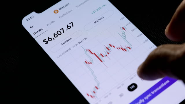 Businessman-is-checking-Bitcoin-price-chart-on-digital-exchange-on-mobile-phone