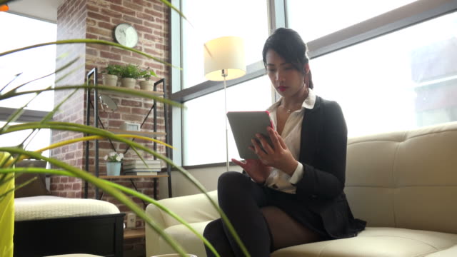Directora-Femenina-Coreana-Mujer-Empresaria-con-Ipad-Tablet-en-hotel