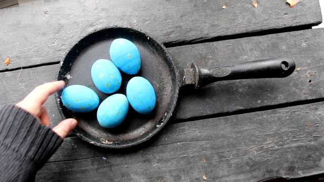 Easter-eggs-in-a-frying-pan-on-rustic-wooden-background