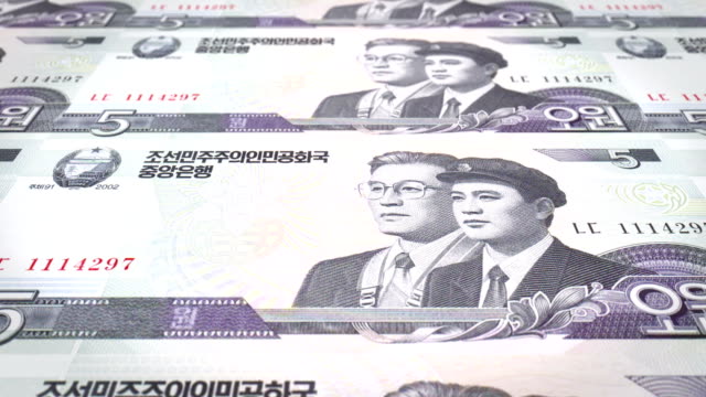 Banknoten-von-fünf-Won-von-Nordkorea-rollen,-Bargeld,-Schleife