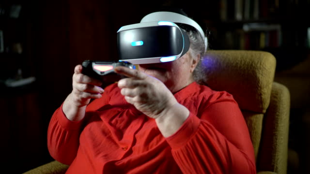 70-Jahre-alte-Frau-beim-Videospiel-verwendet-VR-Kopfhörer-und-Gaming-controller