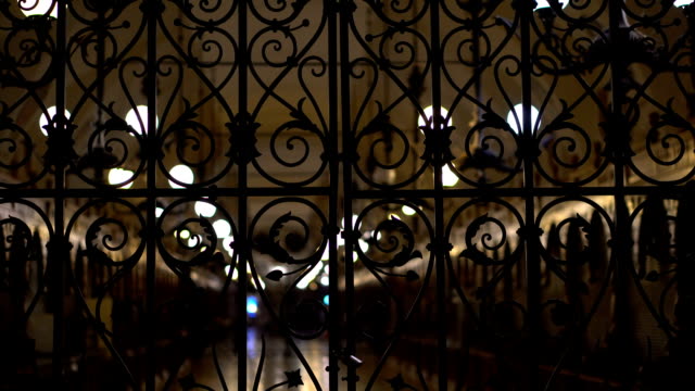 Cloth-Hall-behind-a-locked-iron-gate-night-background