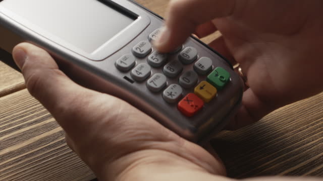 Person-pushing-the-button-and-swipe-credit-card-payment-on-pos-terminal