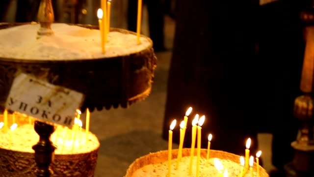 Burning-candles-inside-of-orthodox-church,-paying-respects,-religious-tradition