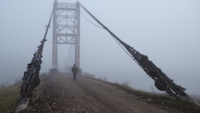 Hombre-caminando-sobre-el-puente-de-la-cuerda-a-través-del-río-Katun-cerca-de-la-aldea-de-Multa