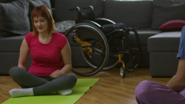 Man-Showing-Yoga-Poses-to-Paraplegic-Woman