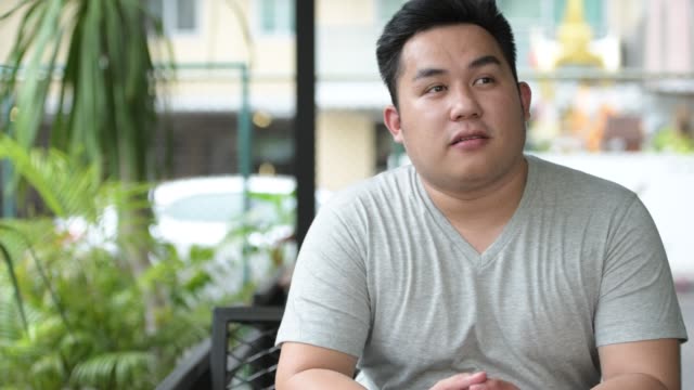 Joven-guapo-sobrepeso-hombre-asiático-de-relax-en-la-cafetería