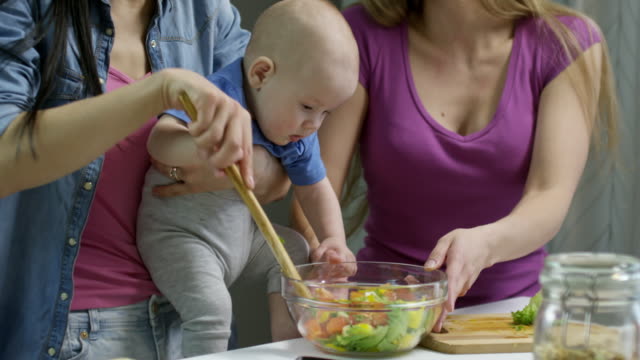 Baby-junge-Mütter-machen-Salat-zu-helfen
