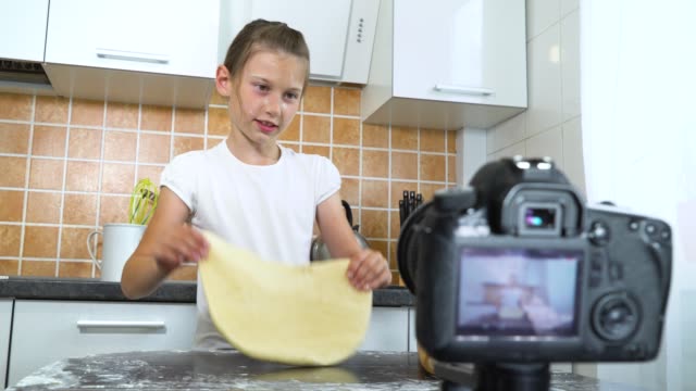 Young-vlogger-recording-video-content-for-food-blog-rolling-dough-with-rolling-pin