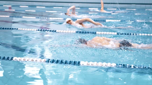 Gruppe-von-jungen-männlichen-sportlich-professionelle-Schwimmer-mit-Crawl-auf-Waterpool-training