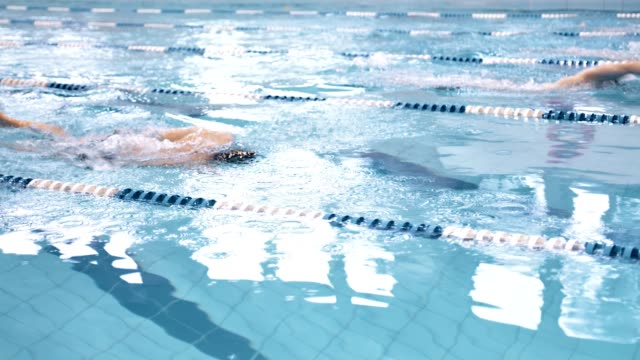 Deportista-masculino-de-alto-ángulo-flotante-en-estilo-crawl-por-pistas-en-el-Campeonato-de-piscina