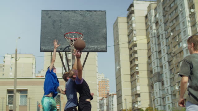 Streetball-players-jumping-to-take-rebound-on-court