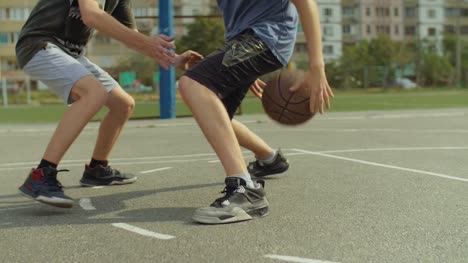 Junger-Mann-am-Basketballplatz-mit-Ball-dribbeln