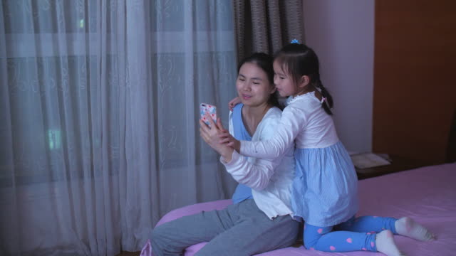 Mother-and-daughter-using-phone-in-home,-4k