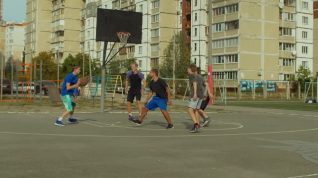 Adolescentes-activos-jugando-streetball-juego-al-aire-libre