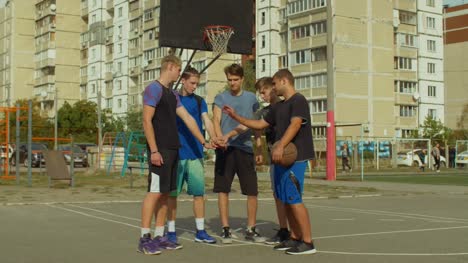 Equipo-de-jugadores-de-baloncesto-apilando-las-manos-en-el-Tribunal