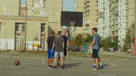 Jugadores-de-baloncesto-adolescentes-estrecharme-la-mano-después-de-partido