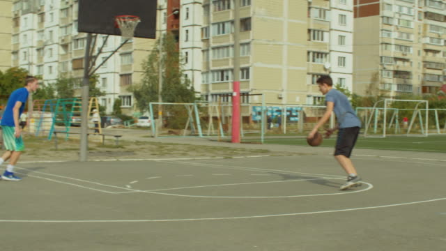 Teenagers-training-basketball-skills-on-outdoor-court