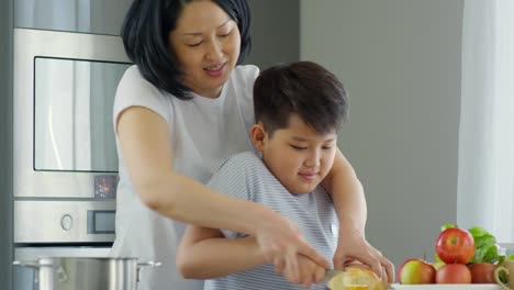 Asiatische-Mutter-Lehre-junge-Messer-verwenden