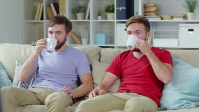 Zwillinge-trinken-Kaffee-beim-Fernsehen